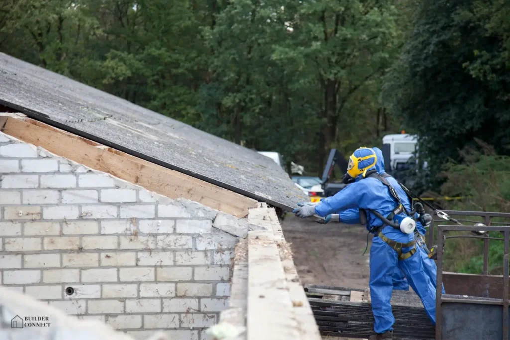 Worker in protective gear removing asbestos roofing during building demolition in New Zealand