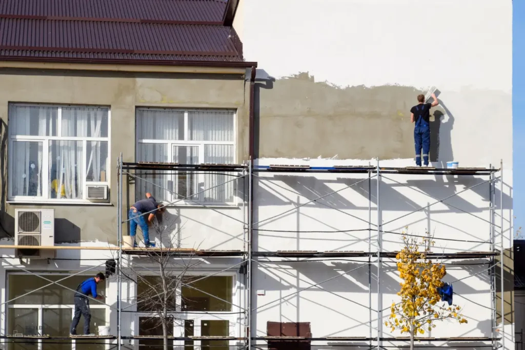 Commercial plastering in New Zealand with contractors working on scaffolding.