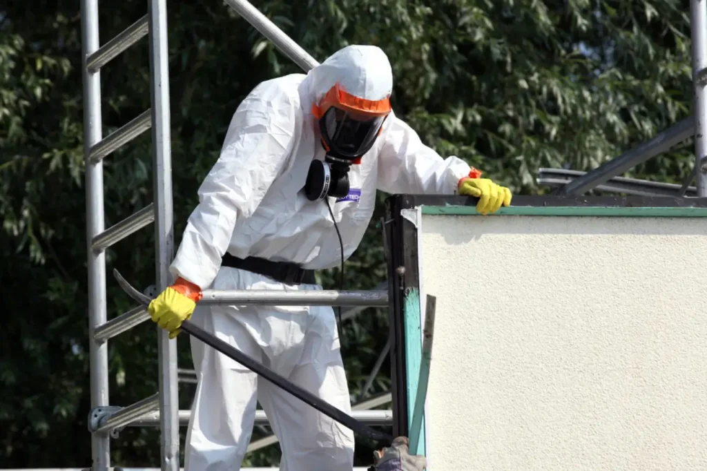 Worker in protective gear carrying out asbestos removal during a building demolition in New Zealand.