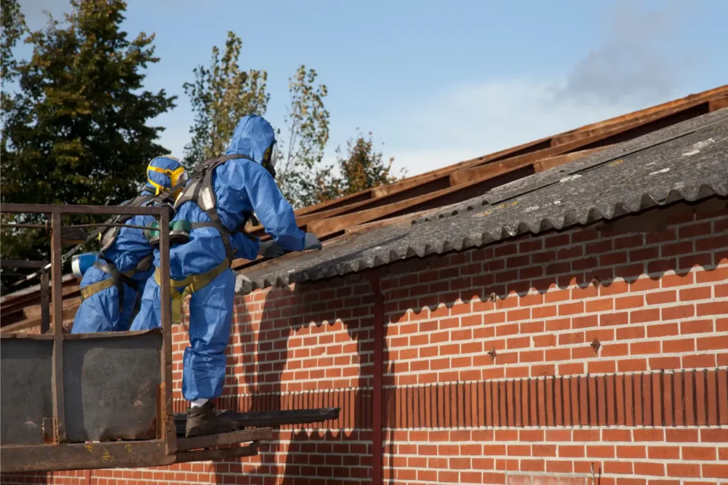 Team in protective suits conducting asbestos removal on a roof in New Zealand.