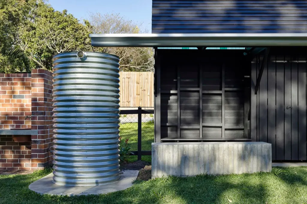 Galvanised steel tank beside a home showing Water Tank Installation in New Zealand NZ.