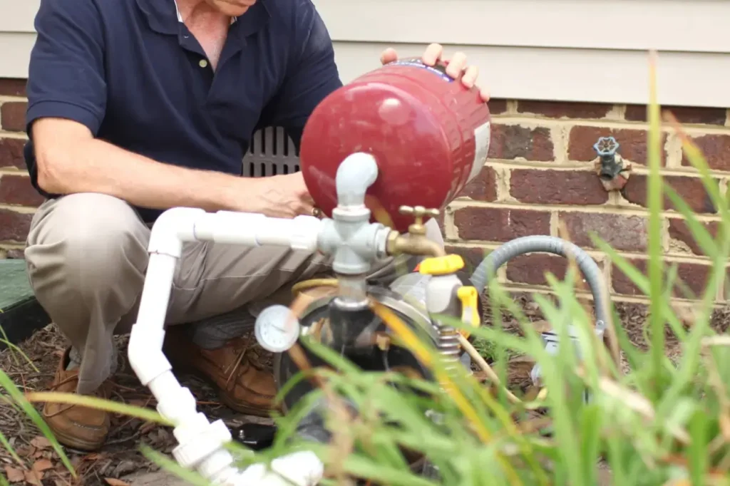 Homeowner inspecting outdoor residential water pump system installed in New Zealand.