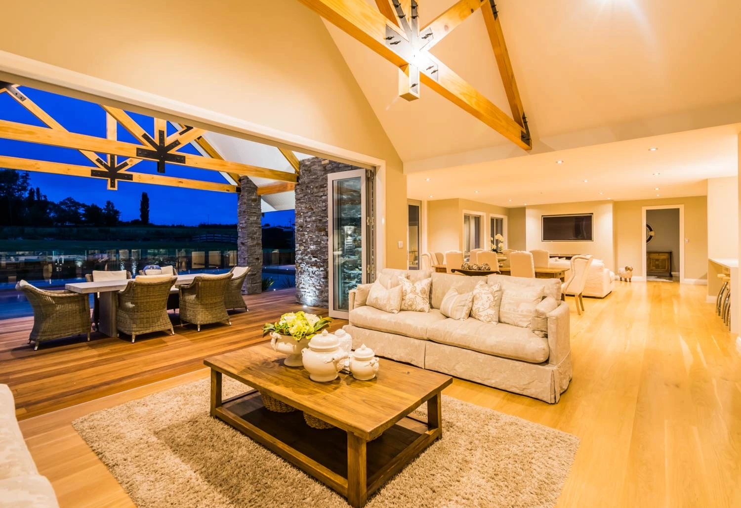 Elegant living room with exposed beams and warm lighting showcasing luxury home builders New Zealand craftsmanship and modern design.