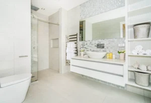 Elegant modern bathroom showcasing expert bathroom renovations New Zealand with contemporary white tiles, vanity, and glass shower.