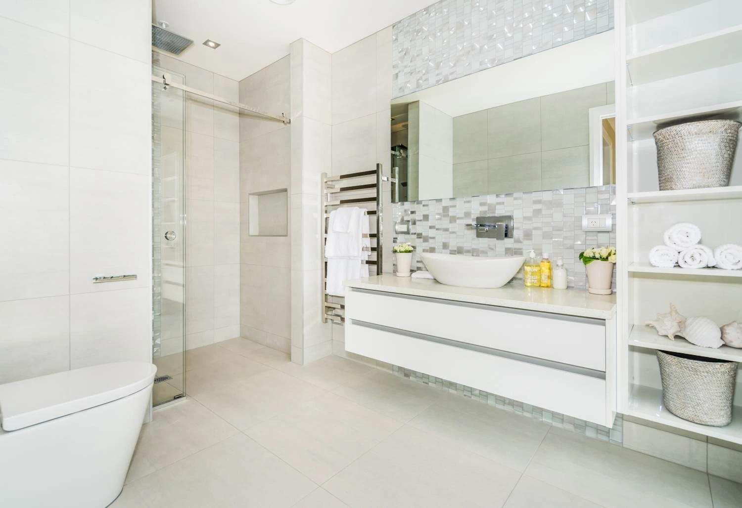 Elegant modern bathroom showcasing expert bathroom renovations New Zealand with contemporary white tiles, vanity, and glass shower.