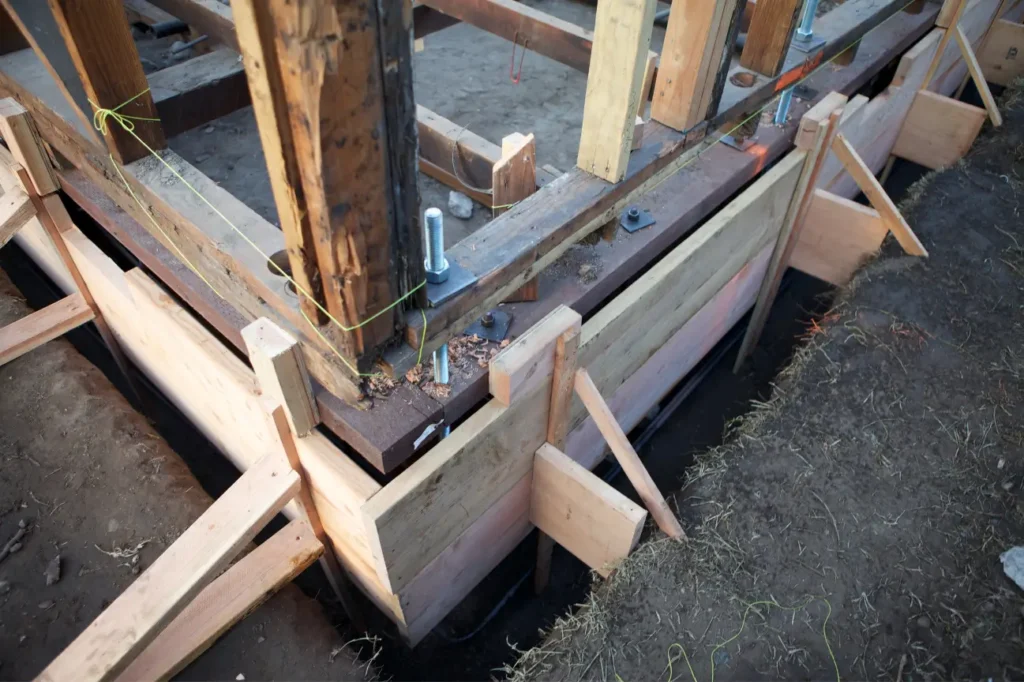 Timber formwork and structural reinforcement installed around a building foundation during repair work by Foundation Contractors New Zealand.