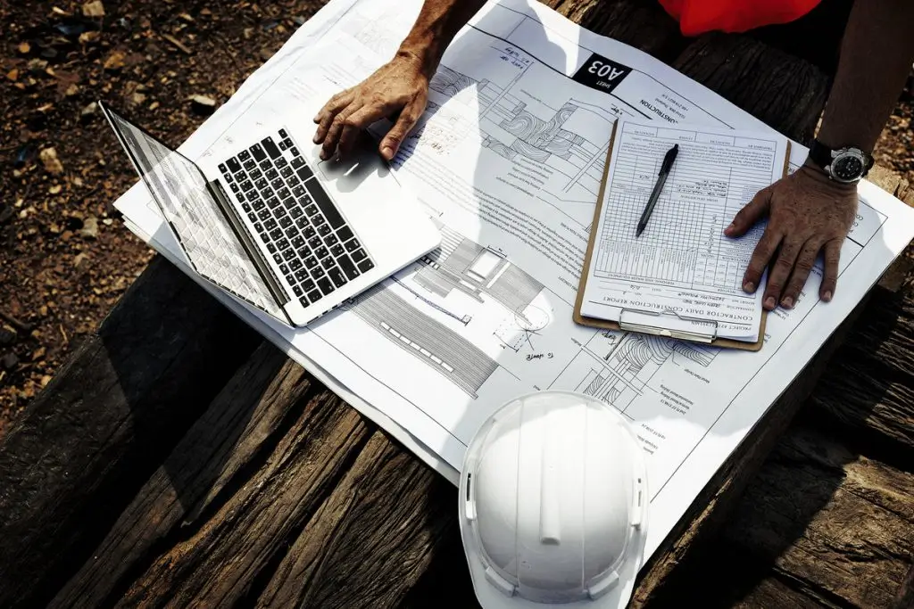 Quantity Surveyor in New Zealand reviewing construction plans, cost estimates, and project documentation on site.