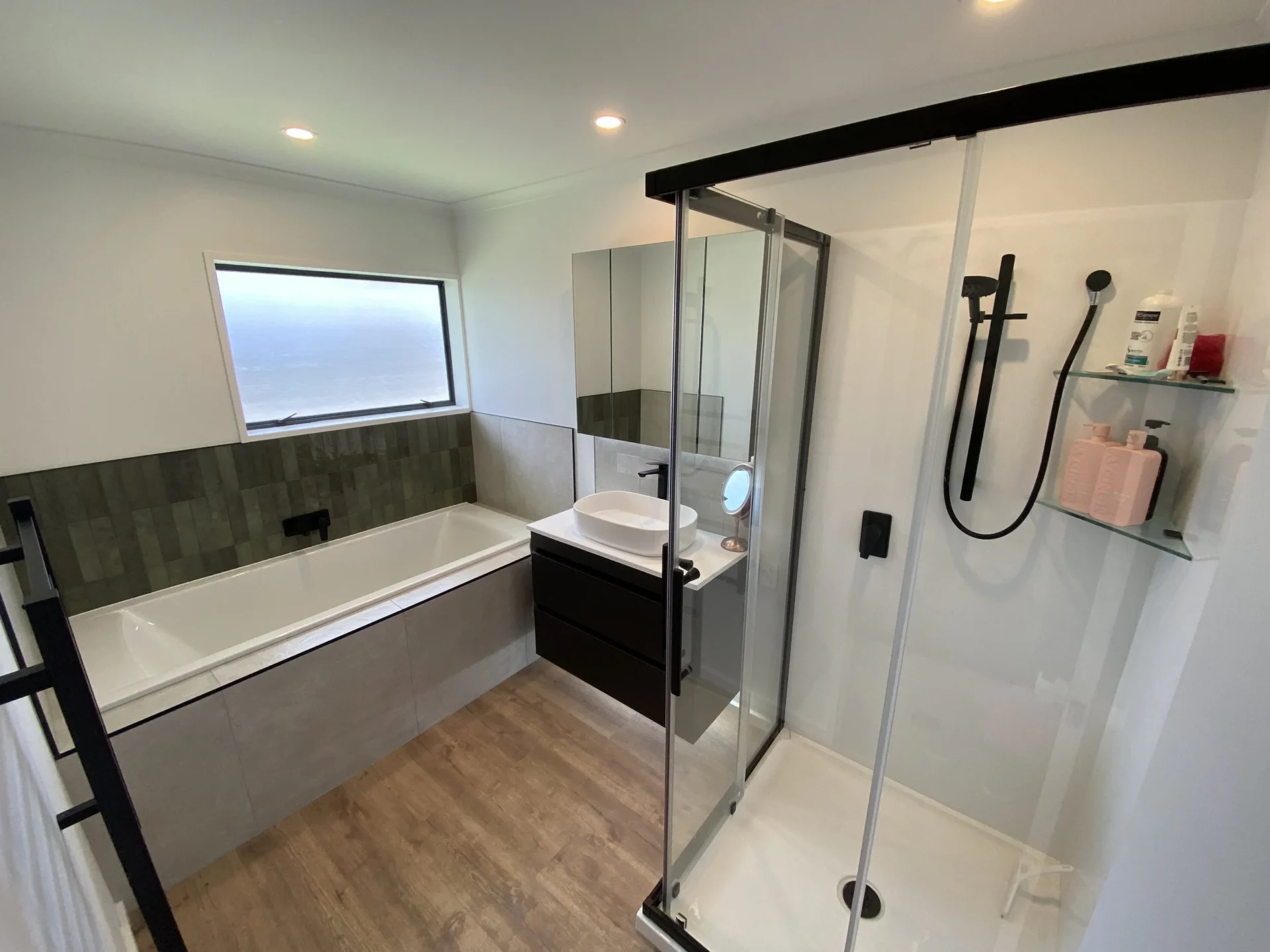 High end Bathroom Renovations in New Zealand featuring a modern shower bath combination and sleek contemporary finishes.