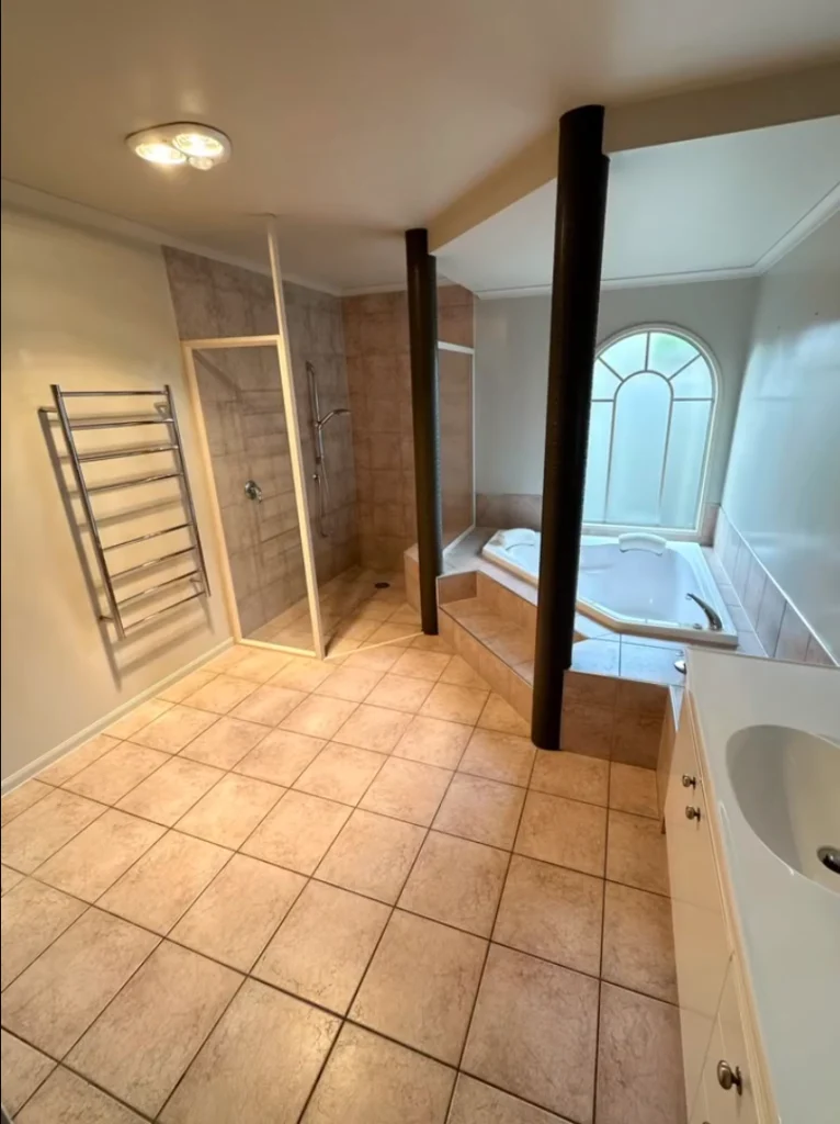 Spacious Bathroom Renovations in New Zealand featuring a tiled walk in shower spa bath and well balanced open layout.