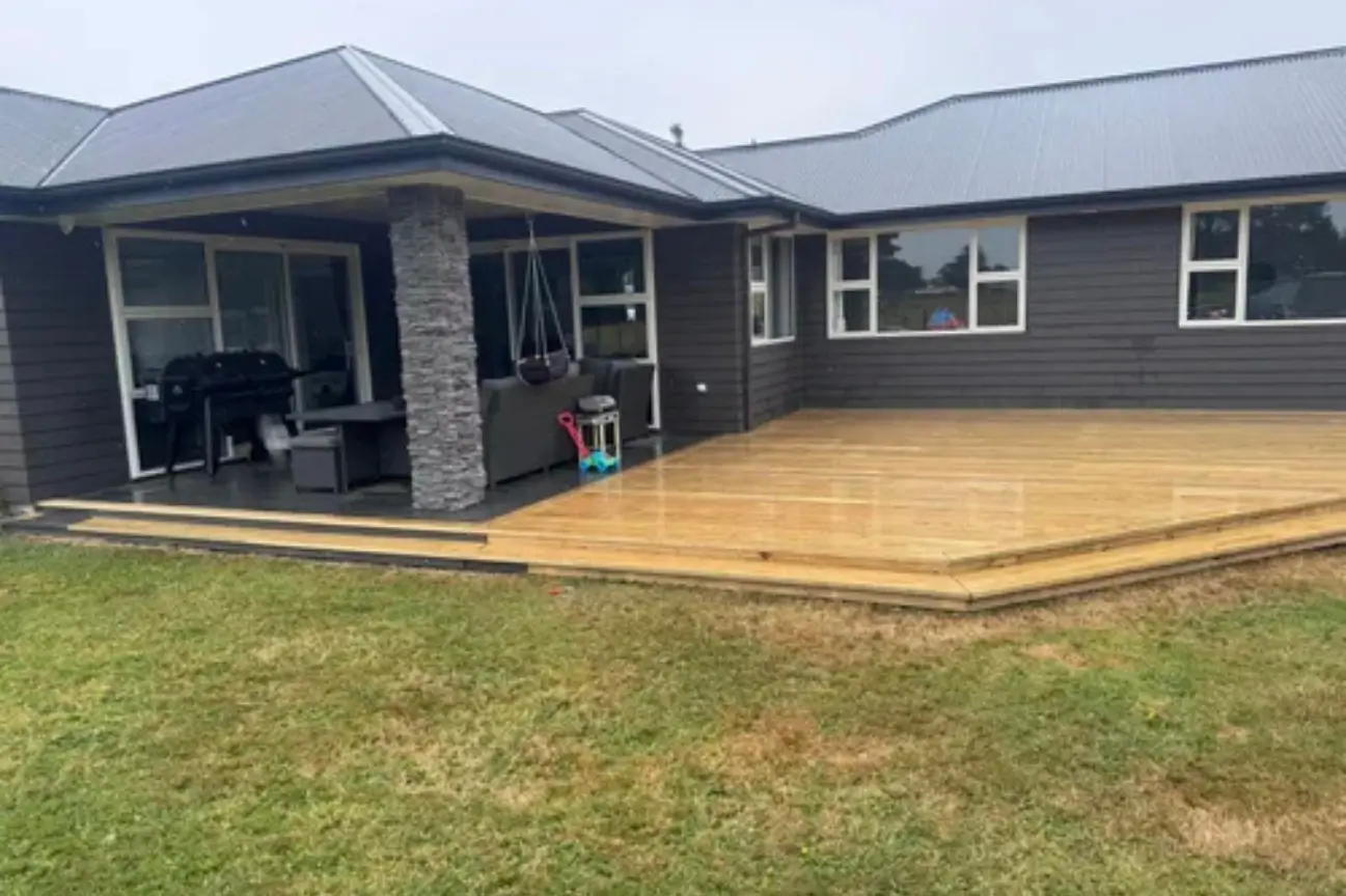 Spacious timber outdoor deck built by professional Deck Builders in New Zealand featuring a covered patio and modern home exterior.