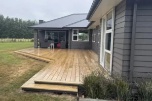 Large wooden backyard deck constructed by trusted Deck Builders in New Zealand alongside a contemporary home.