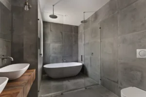 Experienced Tiler in New Zealand installing large format grey bathroom wall and floor tiles with precision.